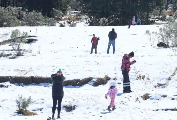 Children and grownups play in the snow in Xalatlaco, México state.