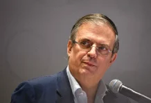 Marcelo Ebrard in front of a microphone looking half sideways