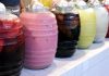 Row of jugs of different-colored aguas frescas