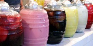 Row of jugs of different-colored aguas frescas