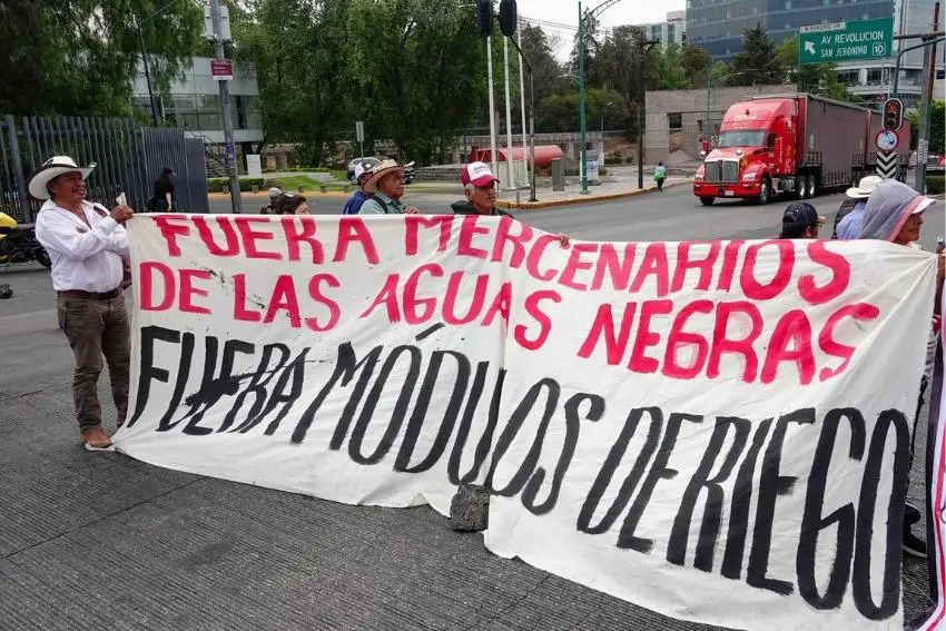 Mexicans holding a large banner on a Mexico City street, protesting poor wastewater management by Conagua.