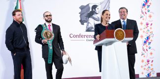 Boxer Canelo Álvarez appears on stage with his manage, who wears sunglasses and carries Álvarez wrestling