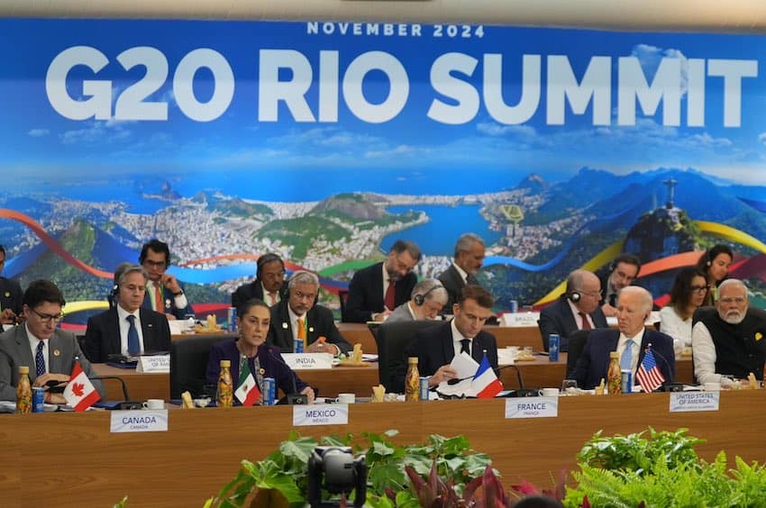 National leaders sit at tables in front of a large banner reading "G20 Rio Summit"