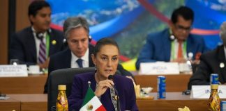 President Claudia Sheinbaum speaks into a microphone at the G20 summit in Rio de Janeiro, Brazil