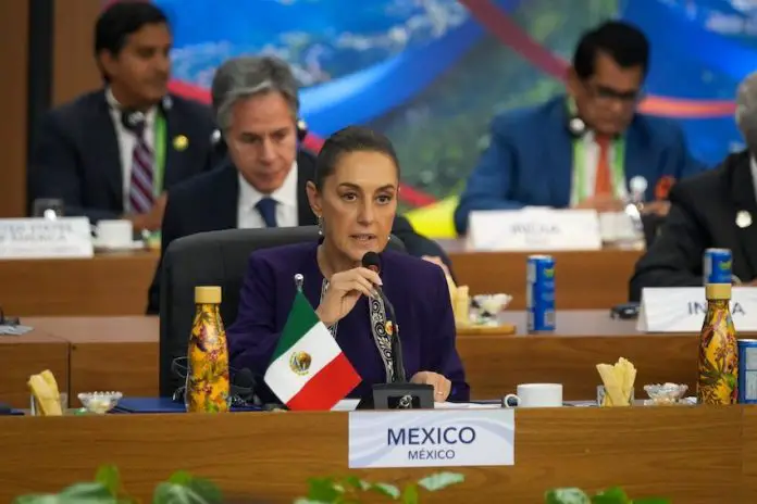 President Claudia Sheinbaum speaks into a microphone at the G20 summit in Rio de Janeiro, Brazil