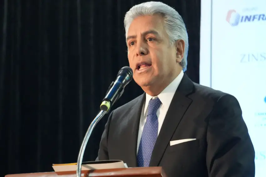 Mexican man standing at a podium in front of a microphone at a conference in Mexico