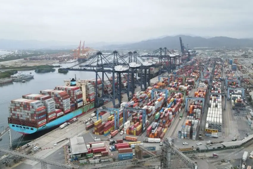 Aerial view of Port of Manzanillo with rows of containers on a concrete loading deck and several cranes along where container ships dock