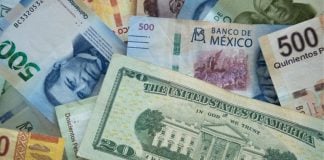 Abstract image of Mexican peso bills and US dollar bills in a chaotic pile