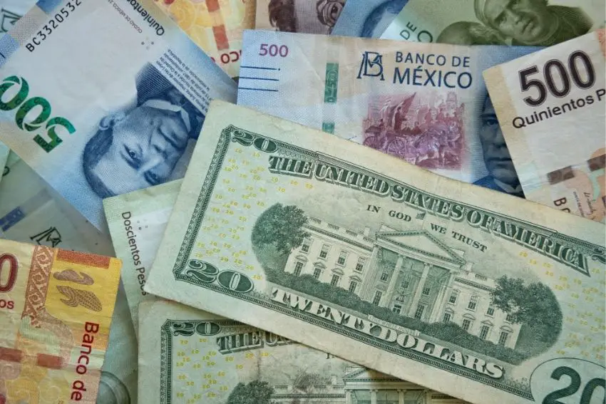 Abstract image of Mexican peso bills and US dollar bills in a chaotic pile