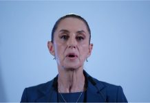 Close up of Mexico's President Sheinbaum's face in mid speech against a bokeh background