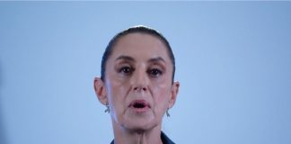 Close up of Mexico's President Sheinbaum's face in mid speech against a bokeh background