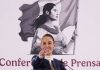 Mexico's President Claudia Sheinbaum at her daily press conference, pointing with her index finger straight into the camera as if taking a reporter's question. Behind her is the logo for her presidency, a black and white illustration of a young Mexican Indigenous woman in a traditional white Mexican dress and holding the Mexican flag.