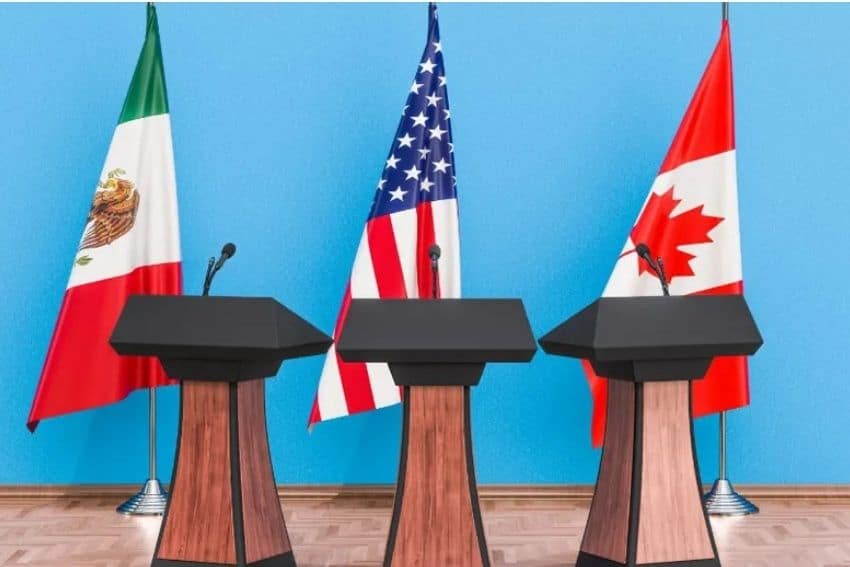 Three podiums on a parquet floor stage, each with a flag behind them - one of Mexico, one of the US and the third of Canada