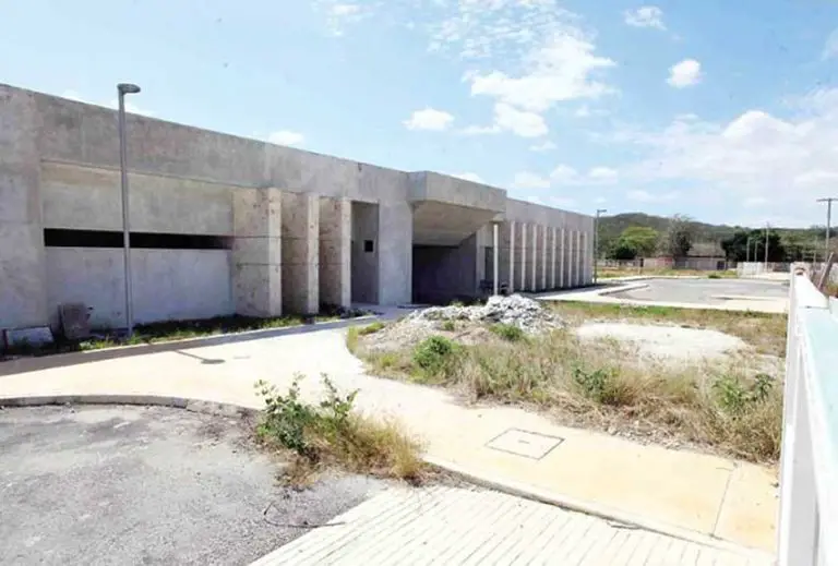 An empty lot with a wide concrete building, an unfinished public healthcare hospital in Veracruz, Mexico.