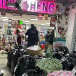officials gather black plastic bags of counterfeit Chinese products outside a store in Mexico City