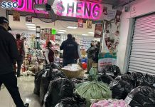 officials gather black plastic bags of counterfeit Chinese products outside a store in Mexico City