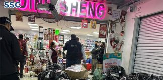 officials gather black plastic bags of counterfeit Chinese products outside a store in Mexico City