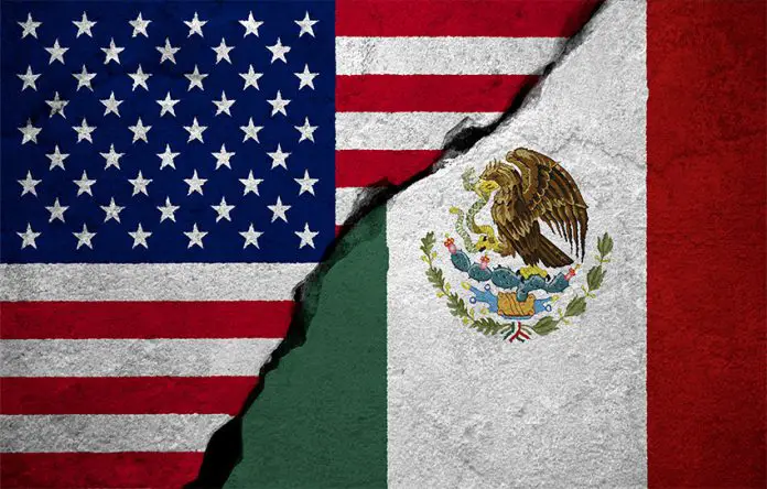 U.S. and Mexican flags with a concrete-like crack running between them.