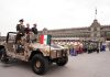 Claudia Sheinbaum rides in a camo military jeep with two military leaders at the Revolution Day parade in Mexico City's main plaza