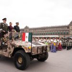 Claudia Sheinbaum rides in a camo military jeep with two military leaders at the Revolution Day parade in Mexico City's main plaza