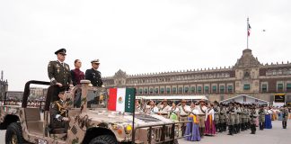 Claudia Sheinbaum rides in a camo military jeep with two military leaders at the Revolution Day parade in Mexico City's main plaza