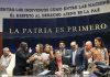 Senate President Gerardo Fernández Noroña, of the Morena party, sits on a legislative dias in front of the words "La Patria Es Primera" as lawmakers argue behind him.