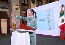 President Claudia Sheinbaum points to the audience from her podium during her morning press conference