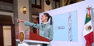 President Claudia Sheinbaum points to the audience from her podium during her morning press conference