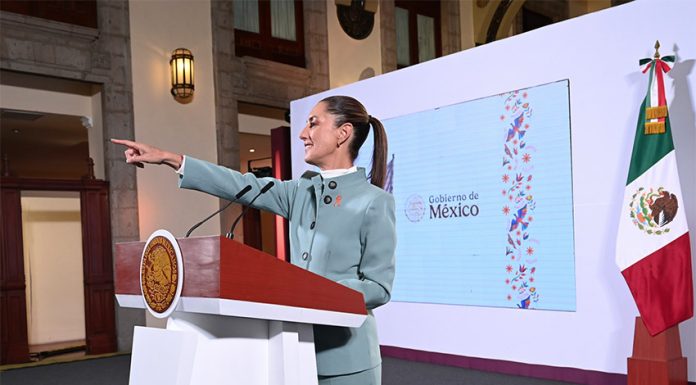 President Claudia Sheinbaum points to the audience from her podium during her morning press conference