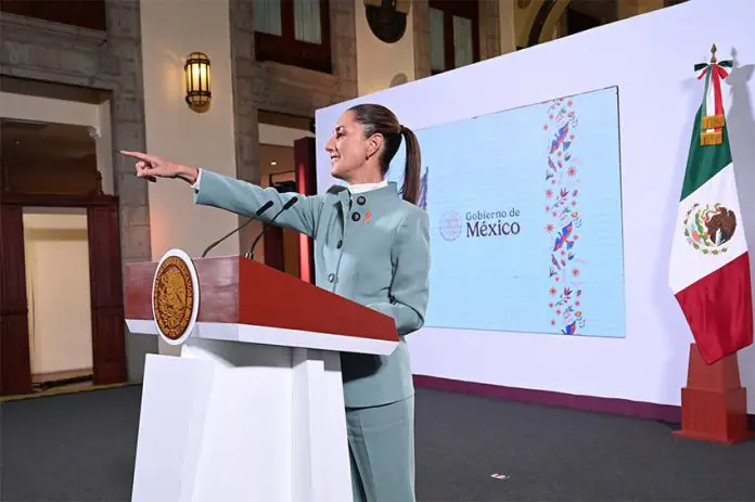 President Claudia Sheinbaum points to the audience from her podium during her morning press conference