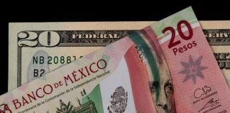A Mexican 20-peso bill and a U.S. 20-dollar bill on an abstract black background. The Mexican bill is laying over the U.S. bill.