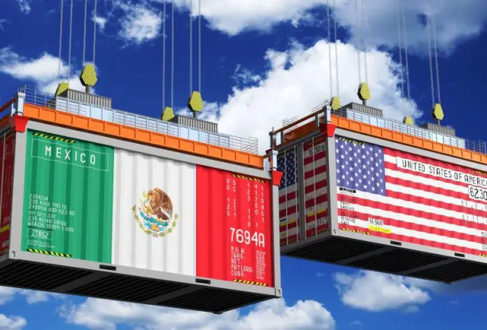 Illustration of two shipping containers hanging by cables in the air. The front of the container on stage left is painted with he flag of Mexico. The container on stage right is painted with the flag of the United States.