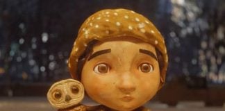 A stop animation still of a little boy in a scarf and and hat with a small owl on his shoulder from the Alfonso Cuaron short film "An Almost Christmas Story"