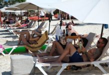 International tourists lay in a row on a sunny Cancún beach