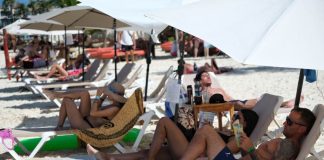 International tourists lay in a row on a sunny Cancún beach