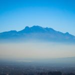 The Mexico City skyline with a layer of fog over it.