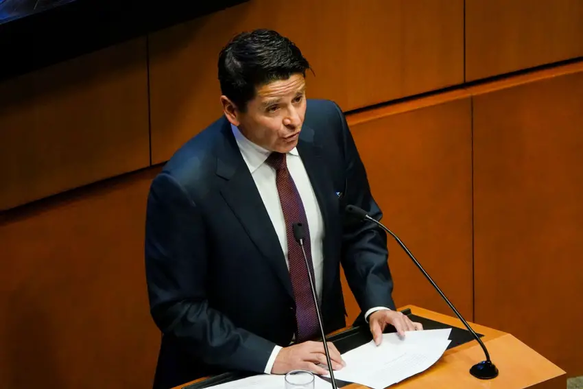 El senador mexicano Cuauhtémoc Ochoa Fernández, de pie detrás de un podio con dos micrófonos, con papeles en la mano, se dirige al Senado federal mexicano fuera de cámara.