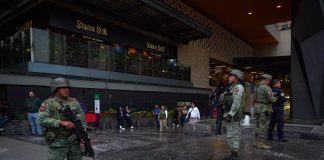 Soldiers stand guard outside a shooting crime scene in a Polanco neighborhood mall, in Mexico City
