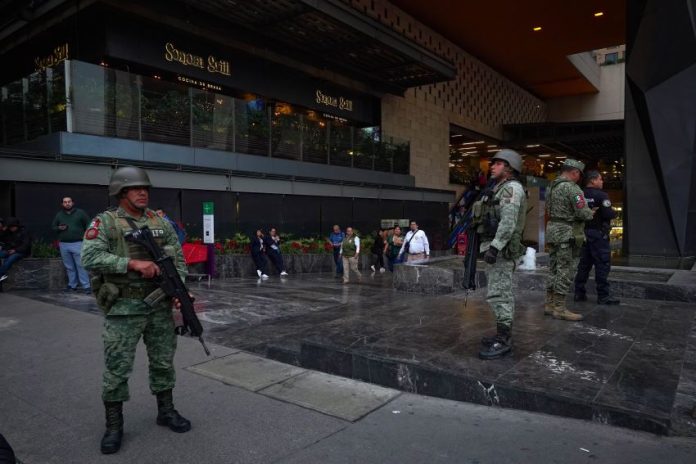 Soldiers stand guard outside a shooting crime scene in a Polanco neighborhood mall, in Mexico City