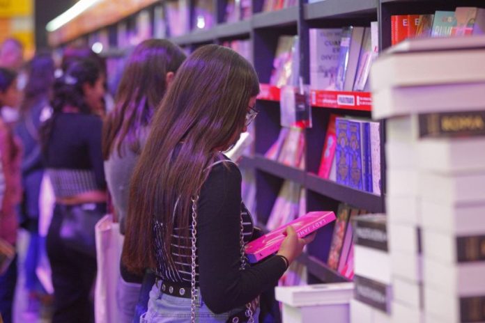 A woman browses books on a shelf at the Guadalajara International Book Fair