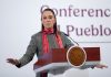 Mexican President Claudia Sheinbaum lead her daily press briefing from a podium, wearing a sweater and scarf