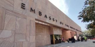 Facade of the new US Embassy in Mexico City. The front of the building is made with pink Mexican cantera stone arranged in rectangles of different sizes and faces a wide courtyard.