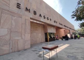 Facade of the new US Embassy in Mexico City. The front of the building is made with pink Mexican cantera stone arranged in rectangles of different sizes and faces a wide courtyard.