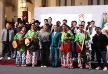 President Claudia Sheinbaum, front center, posing with a group of musicians in traditional Mexican indigenous clothing