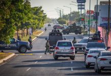 Police and security officials block the street of a crime scene in Culiacán, Sinaloa, where a federal agent was killed.