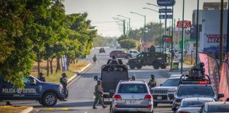 Police and security officials block the street of a crime scene in Culiacán, Sinaloa, where a federal agent was killed.