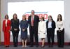 7 men and women standing on a stage