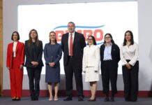 7 men and women standing on a stage