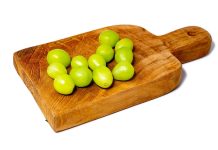 12 green grapes on a wooden serving board