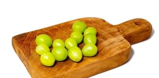 12 green grapes on a wooden serving board